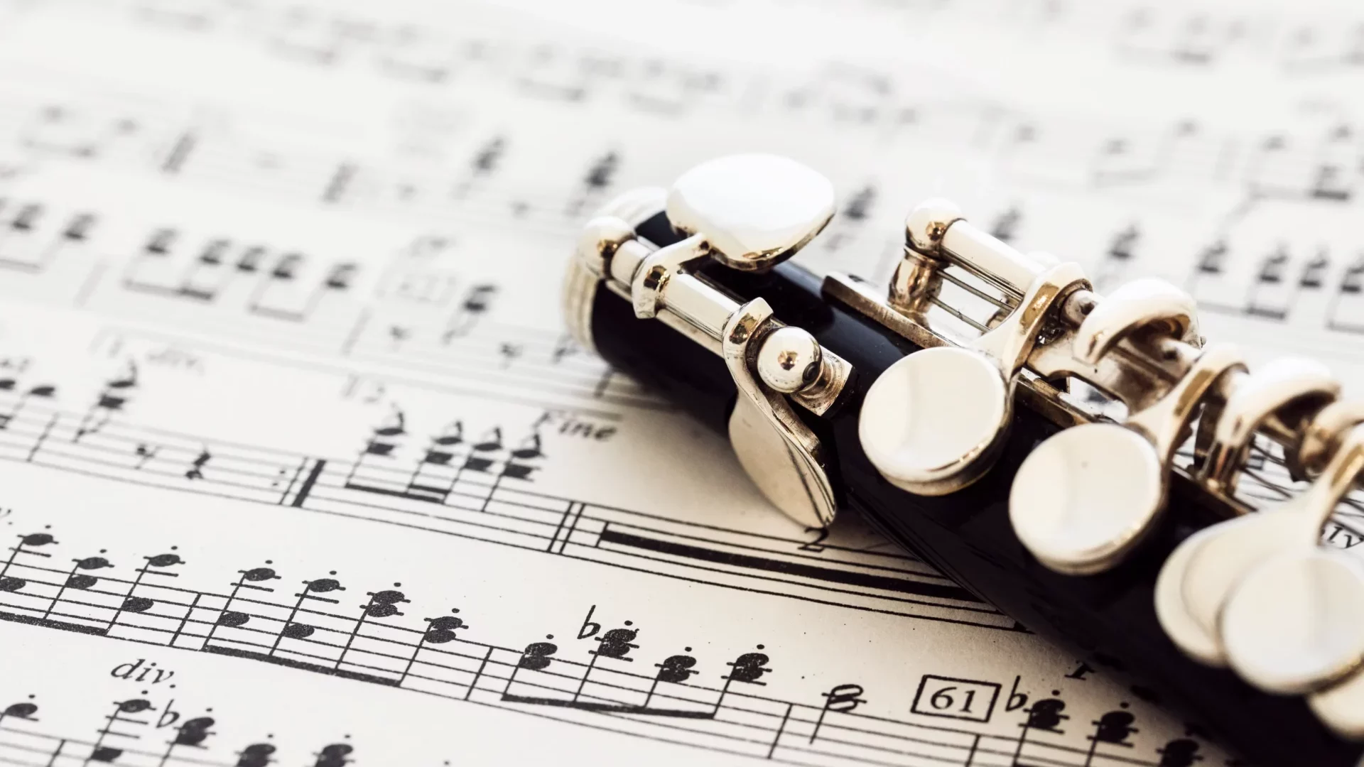 Clarinette posée sur une partition musicale, symbolisant la création de compositions uniques pour accompagner la dégustation de vin.