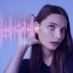 Femme attentive à une onde sonore numérique illustrant une technologie d'innovation en communication sonore